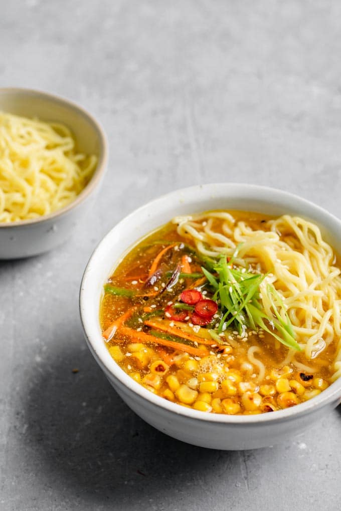 vegan ramen with miso tahini broth, charred corn, and carrots and jalapeño, served with an extra bowl of ramen noodles