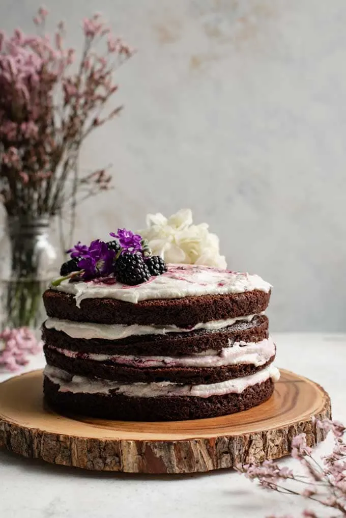 blackberry lavender chocolate cake with blackberry lavender jam, flour buttercream, and decorated with fresh blackberries and flowers
