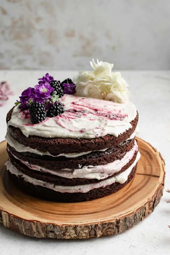 angled view of the blackberry lavender cake to show the jam marbled in the frosting on top of the cake