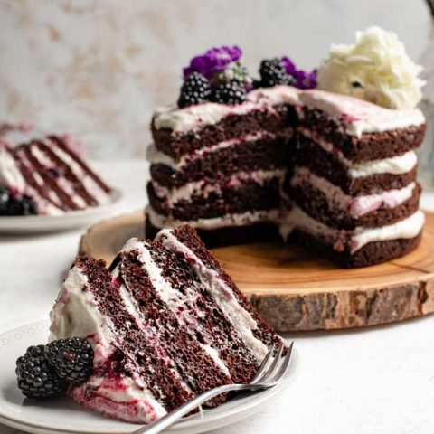 vegan blackberry lavender chocolate cake, with a slice cut out and served on a plate