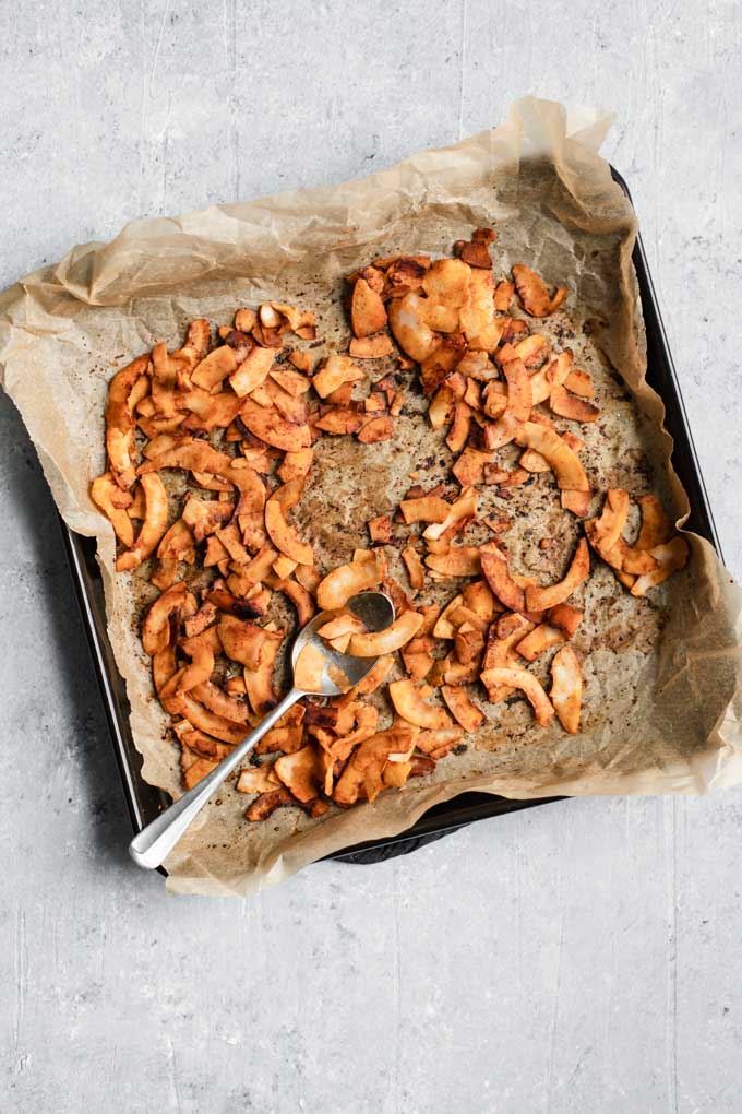 baked coconut bacon on a parchment paper lined baking tray