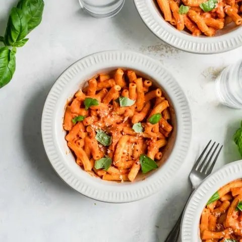 pasta tossed with vegan vodka sauce and garnished with torn basil, vegan parmesan, and some red pepper flakes