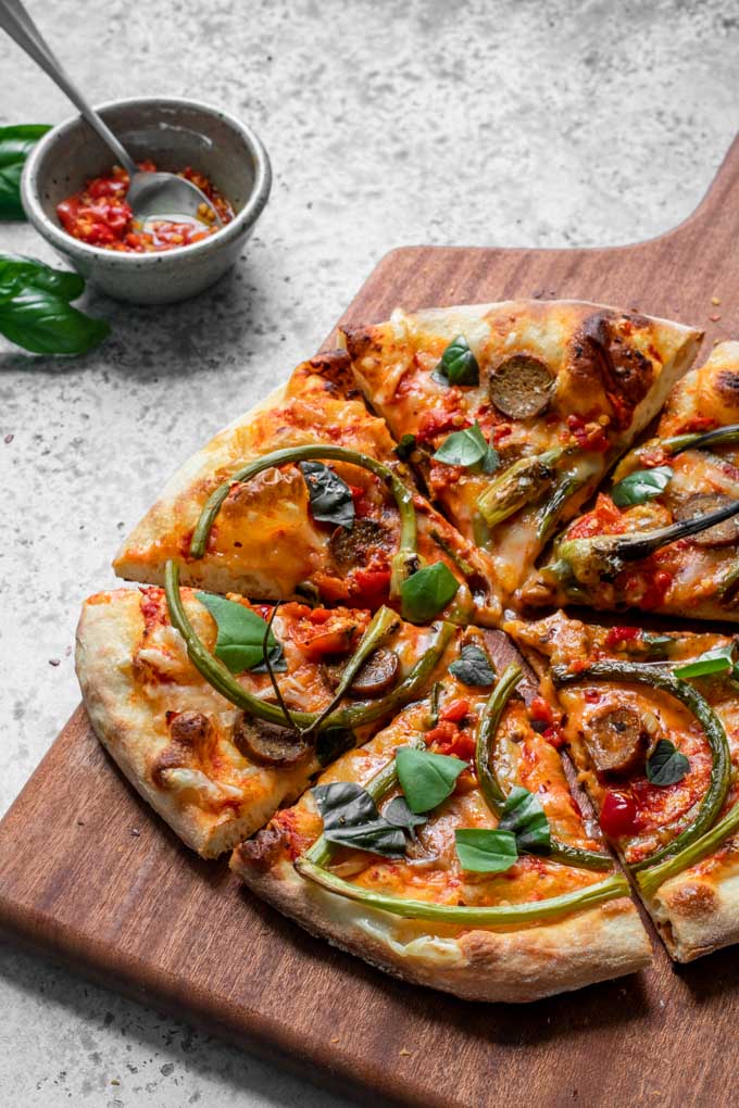 angled view of sliced garlic scape pizza 