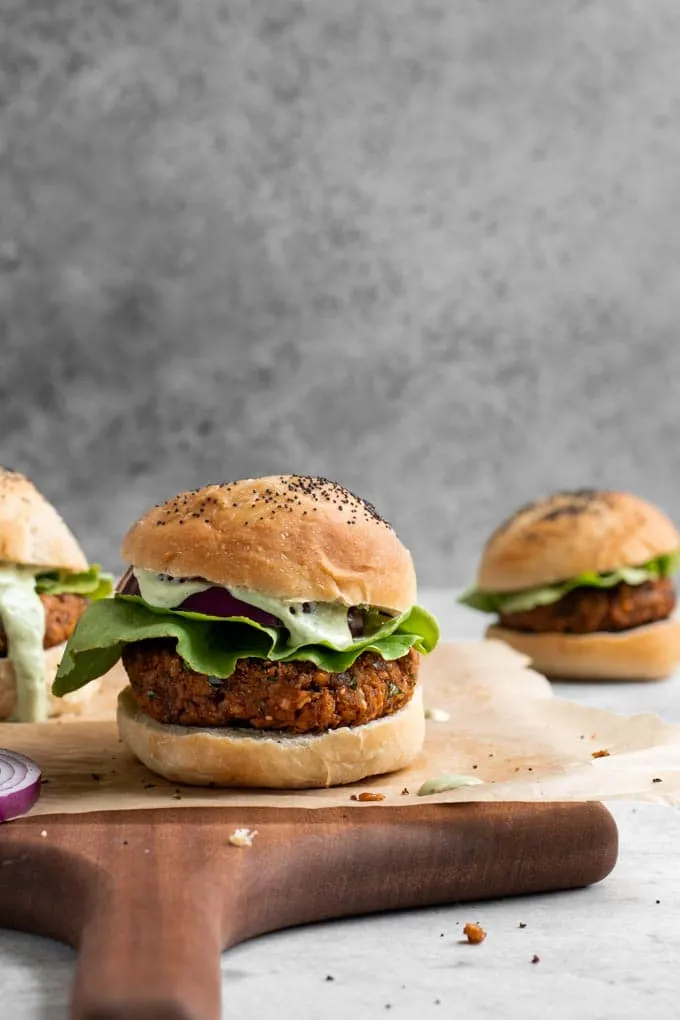 herbed chickpea burgers served on vegan milk bread buns with lettuce, red onion, and a pesto cashew aioli