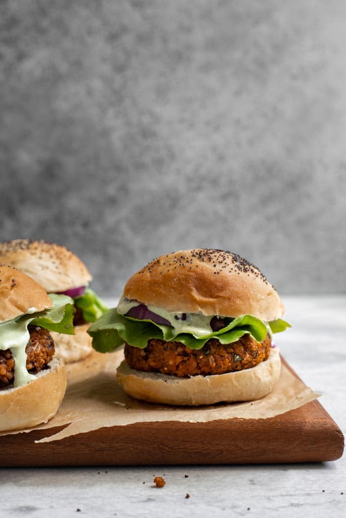 three herbed chickpea burgers served on a parchment lined cutting board