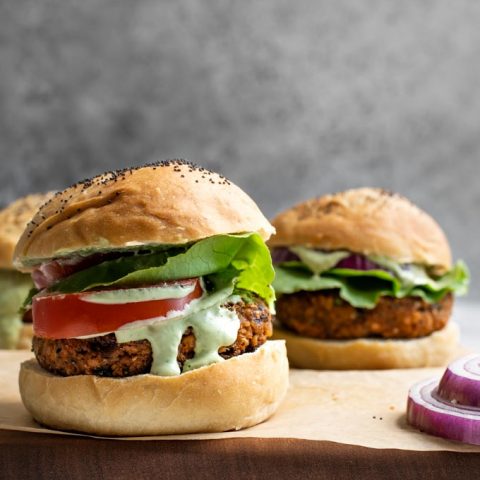 close up of herbed chickpea burgers served with a pesto cashew aioli