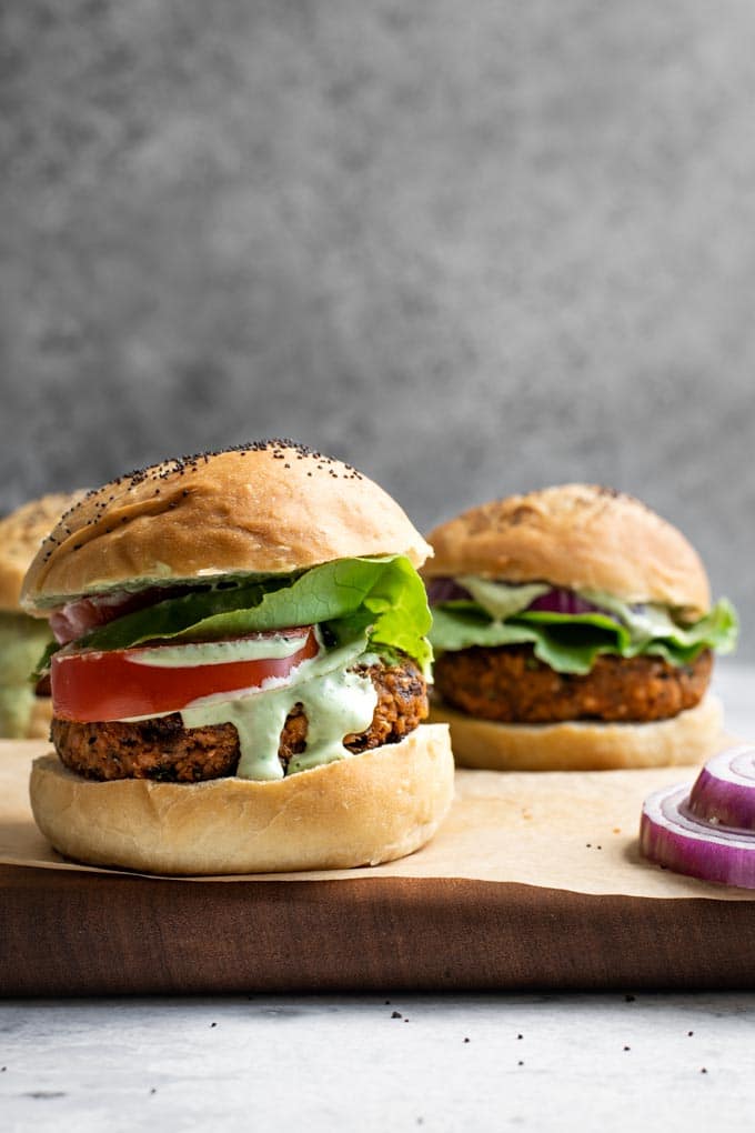 close up of herbed chickpea burgers served with a pesto cashew aioli
