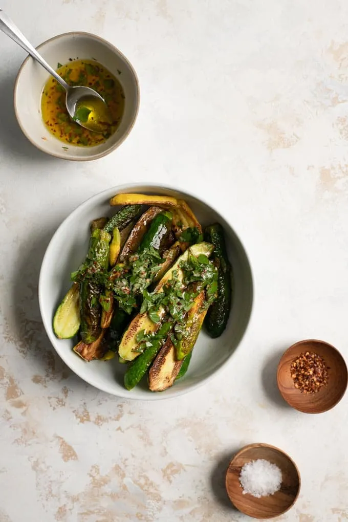 the marinade being spooned over the pan fried zucchini