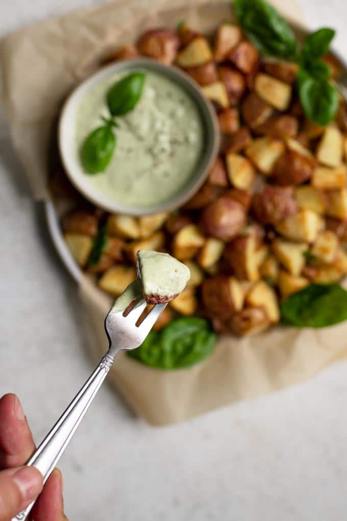 close up of a roasted potato dipped in the pesto cashew aioli