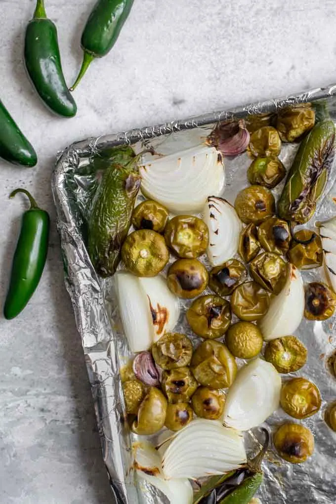 salsa verde ingredients after roasting, the tomatillos are more yellow then green and the jalapeÃ±os are blistered