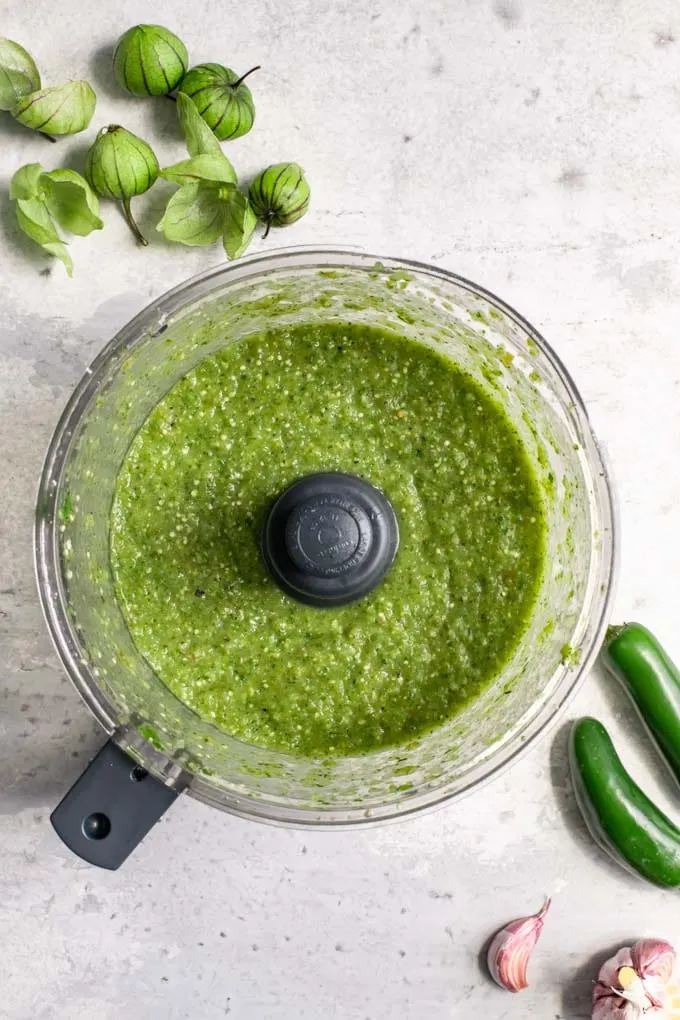 tomatillo salsa in the food processor after it has been blended to make a sauce