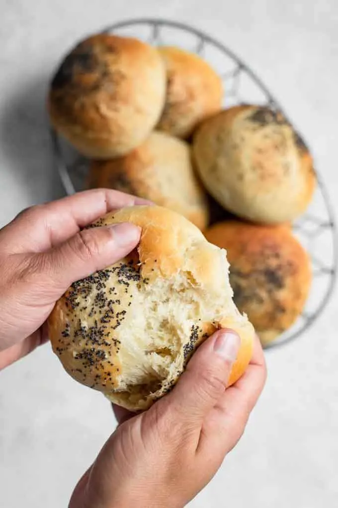 tearing apart a bun to show the texture of the vegan milk bread