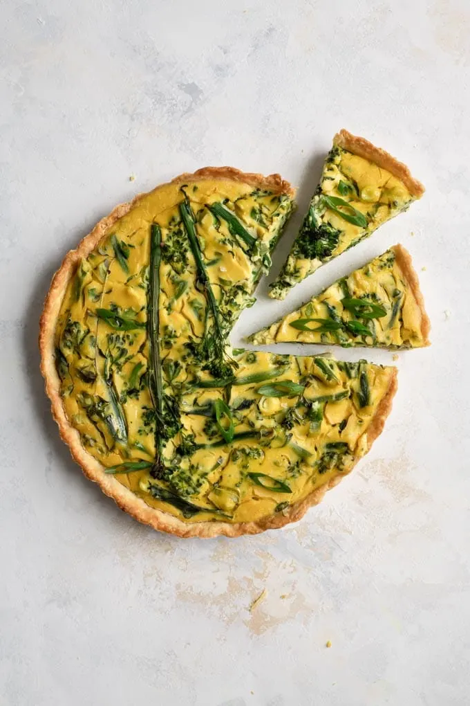 two slices cut from the 9" vegan sprouting broccoli quiche, being removed to serve