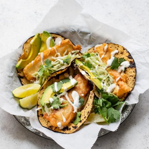 angled view of three Baja tofu tacos on a parchment lined plate