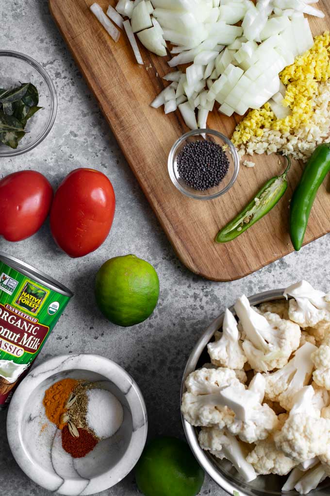 ingredients for moilee curry laid out in a flat lay. Vegetables are cut and spices are measured out and ready to go.