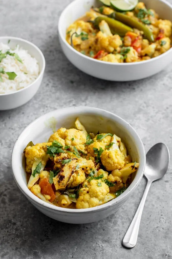 cauliflower moilee curry served in a bowl, garnished with cilantro