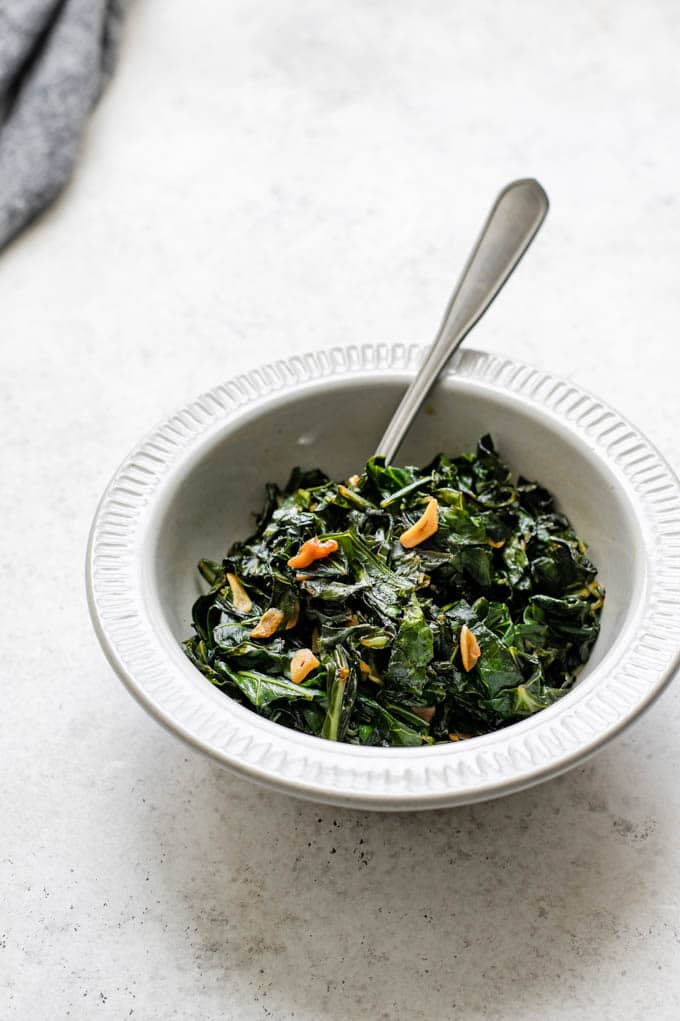 side view of the cooked collard greens in a bowl