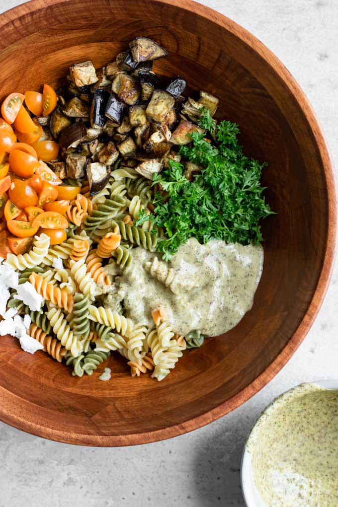 all the ingredients for the pasta salad in a large bowl, before mixing together