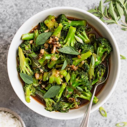 broccoli in garlic sauce served in a bowl with thai basil and jasmine rice