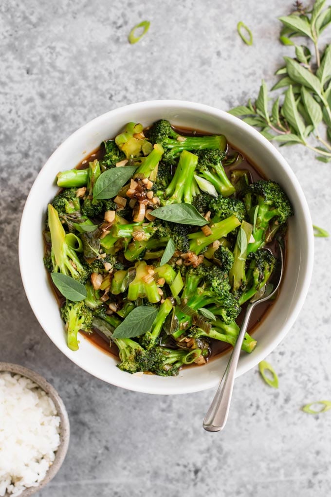 broccoli in garlic sauce served in a bowl with thai basil and jasmine rice