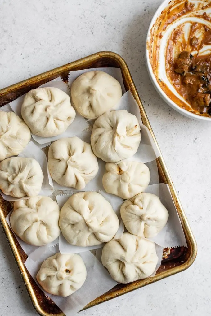 shaped eggplant bao before steaming and a mostly empty bowl of filling