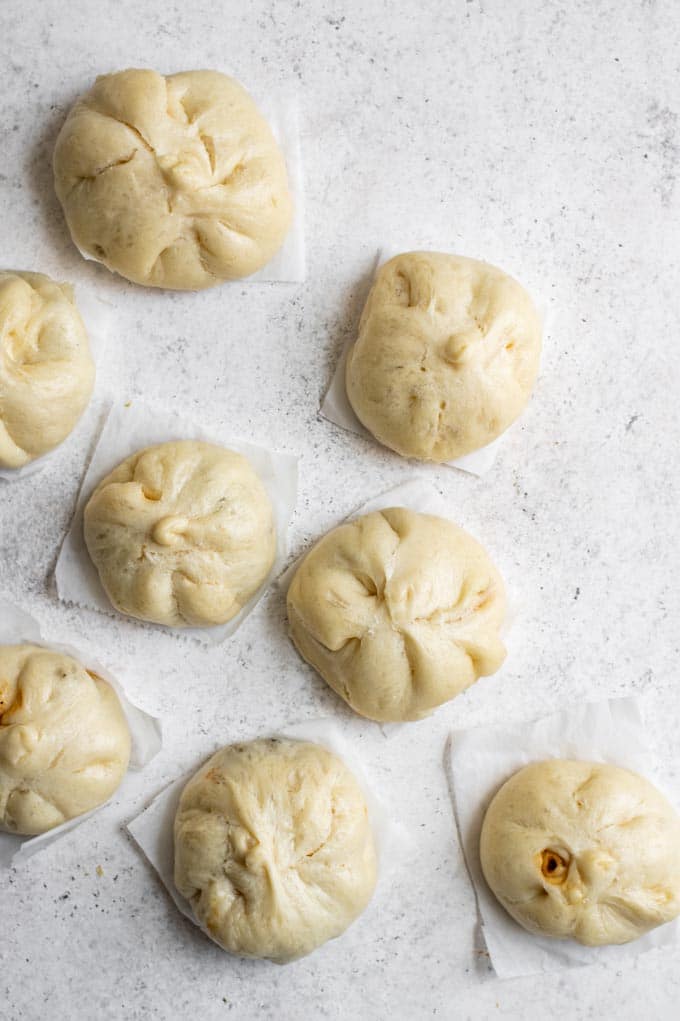 steamed bao on parchment paper squares