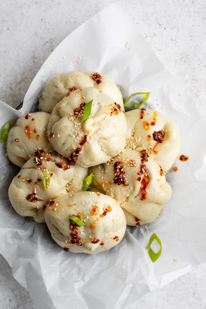 hoisin eggplant bao in a bowl drizzled with chili oil and garnished with scallions