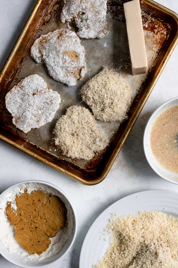 seitan cutlets being breaded with the flour, bread crumb, and flax egg stations