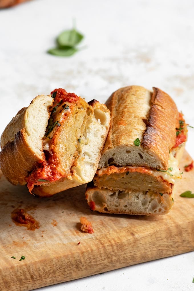 vegan seitan chicken parmesan sandwich cut in half and closeup shown