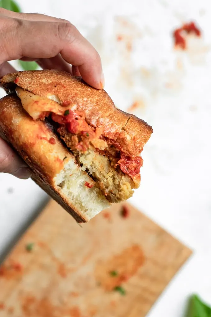 vegan chicken parmesan sandwich with a bite taken out of it