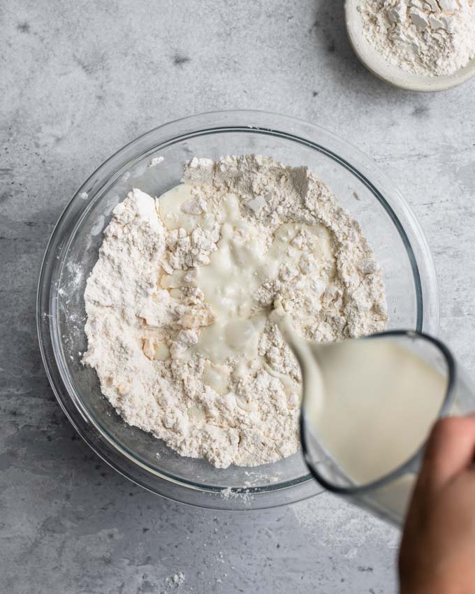 pouring the vegan buttermilk into the dry mixture