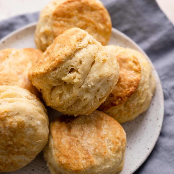 flaky vegan biscuits on a plate resting on a linen napkin