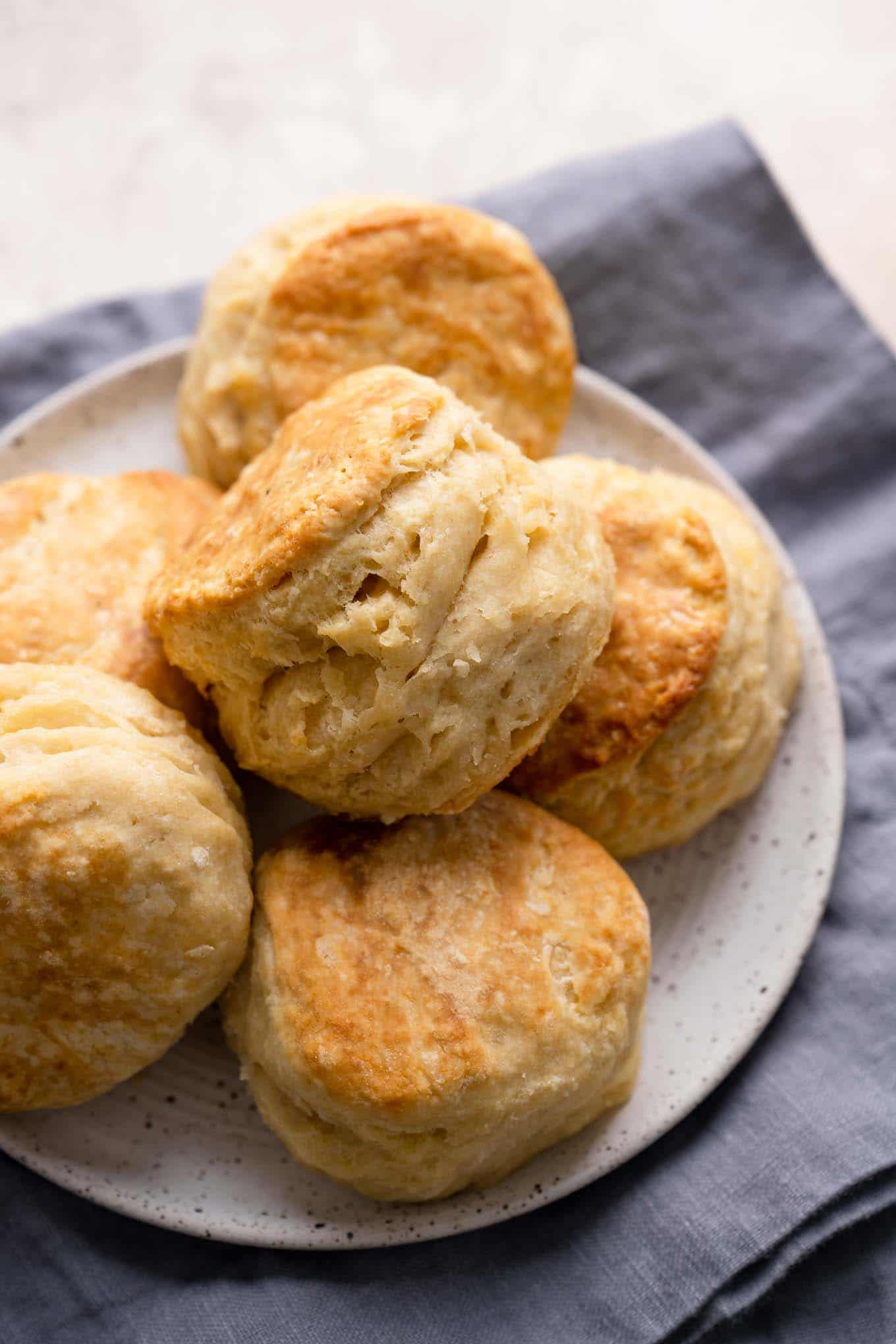 flaky vegan biscuits on a plate resting on a linen napkin