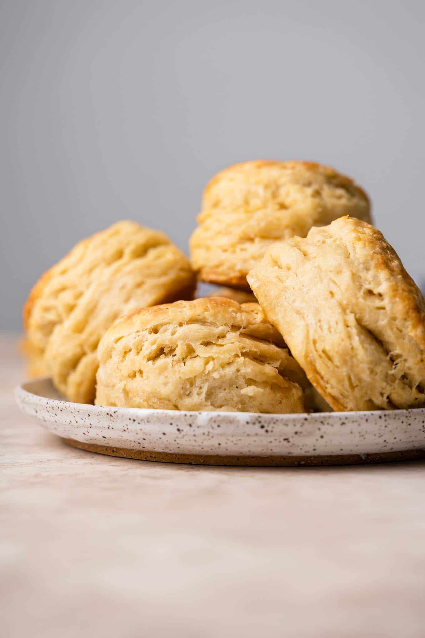 side view of vegan biscuits piled on a plate showing the flaky layers