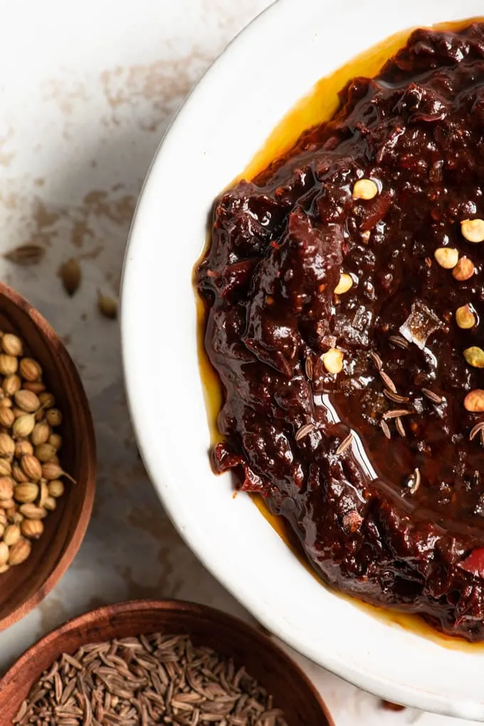 harissa garnished with oil, chili seeds, and flaked sea salt