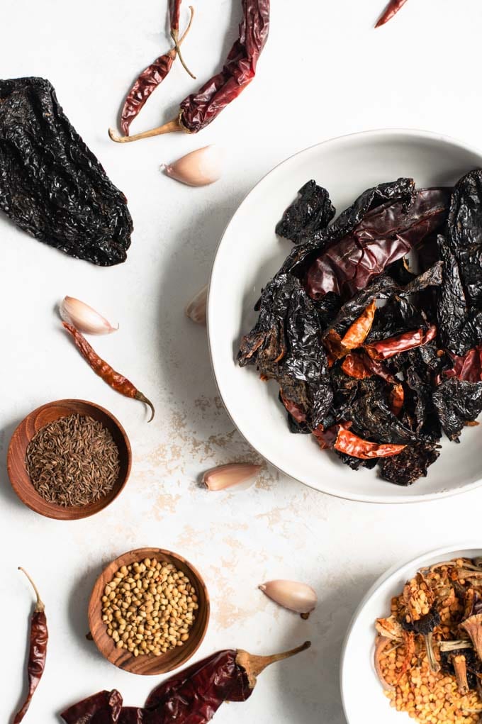 seeded dried chiles with seeds and stems separated, coriander, caraway, and garlic