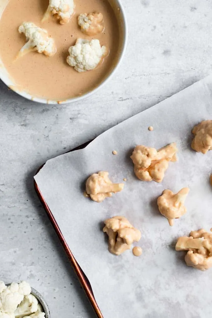 cauliflower florets dipped in a chickpea batter and arranged on a baking tray