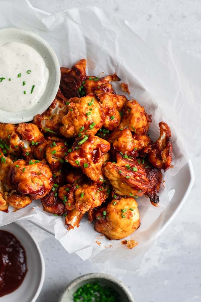 cranberry barbecue cauliflower wings served with ranch, extra barbecue sauce and chives for garnish