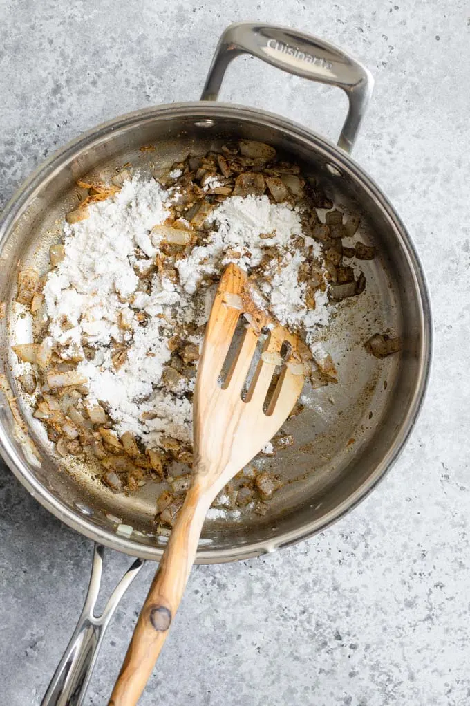 add flour to onion, garlic, and spices in pan