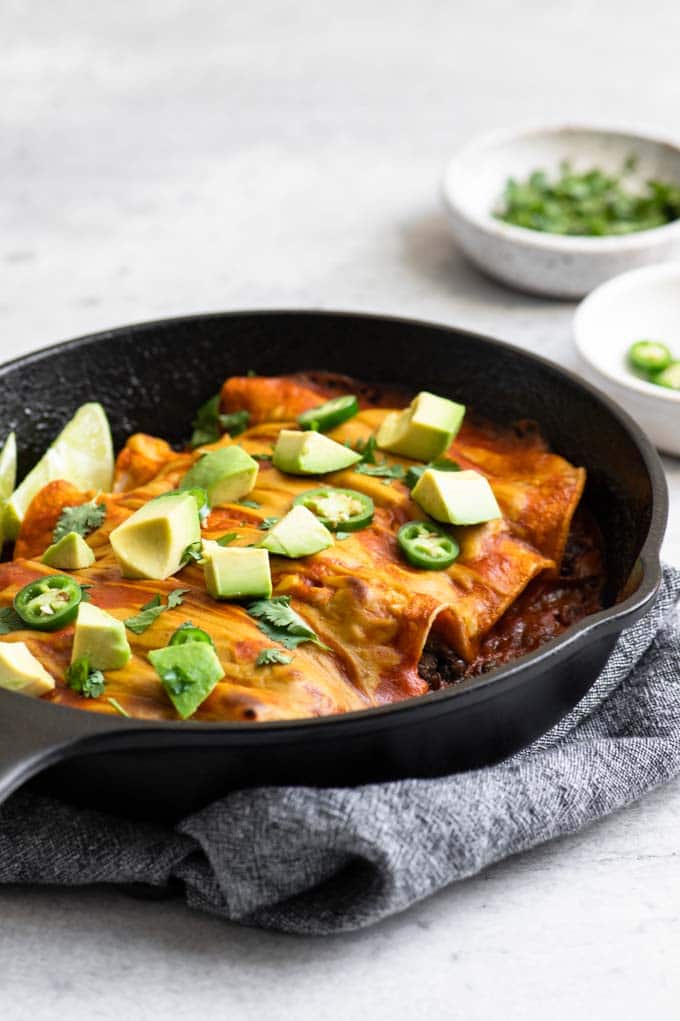 lentil enchiladas topped with avocado, cilantro, and jalapeño