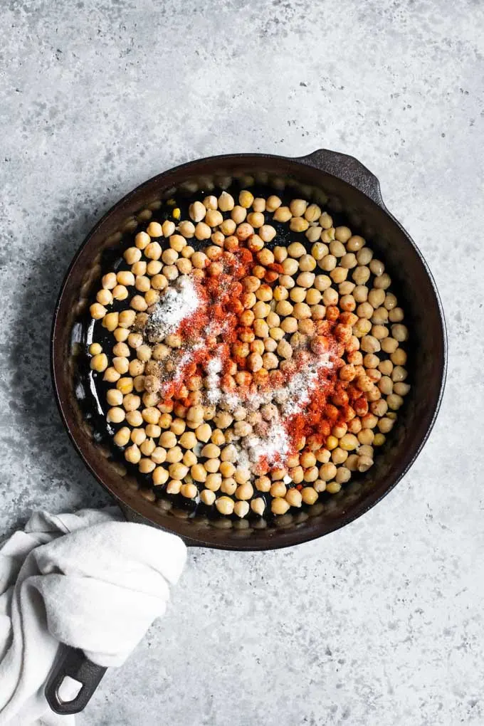 chickpeas in a skillet with chorizo spices sprinkled on top
