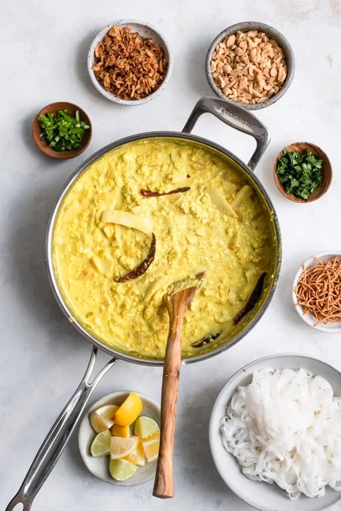 prepared curry, noodles, and toppings laid out for the kaukswe