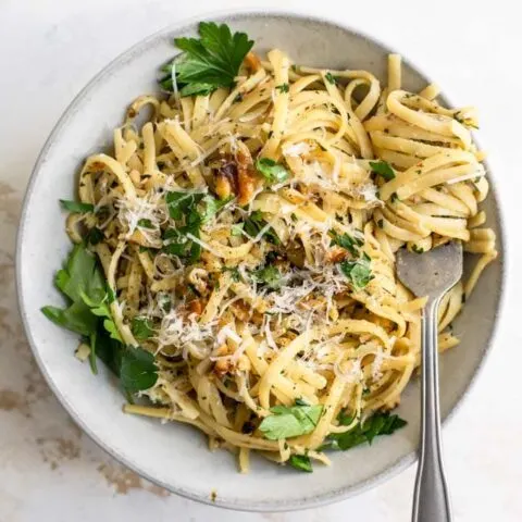 walnut parsley linguine garnished with vegan parmesan and fresh parsley