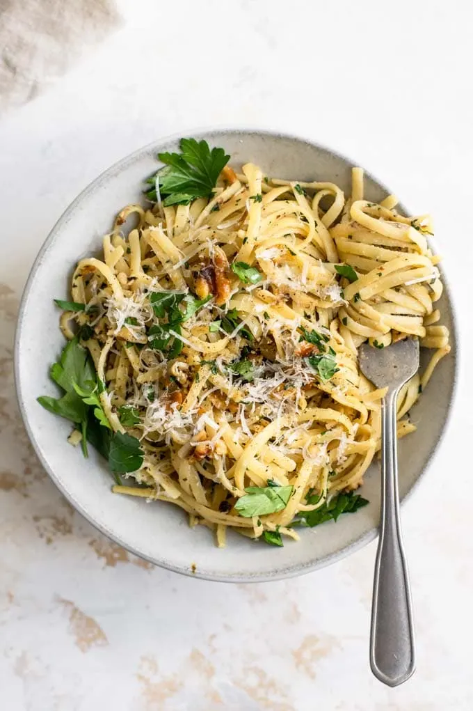 walnut parsley linguine garnished with vegan parmesan and fresh parsley