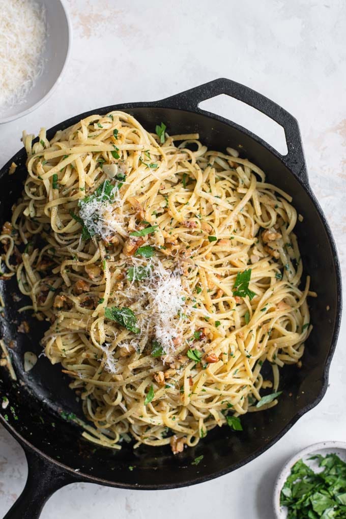 walnut parsley linguine in the skillet topped with vegan parmesan and parsley