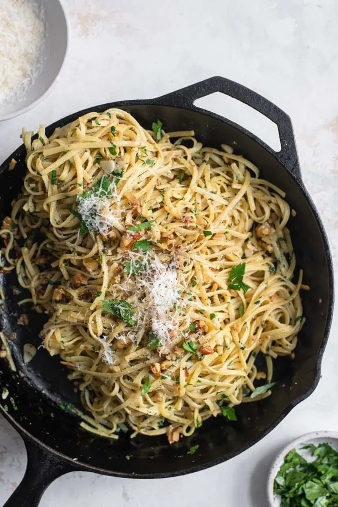 walnut parsley linguine in the skillet topped with vegan parmesan and parsley