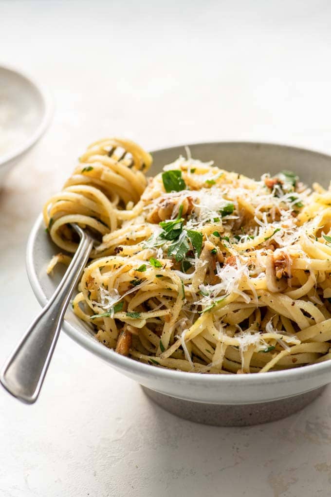 walnut parsley linguine in a bowl with a forkful of twirled pasta