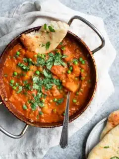 Indian spiced potatoes and peas curry served with garlic naan