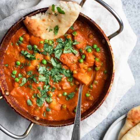 Indian spiced potatoes and peas curry served with garlic naan