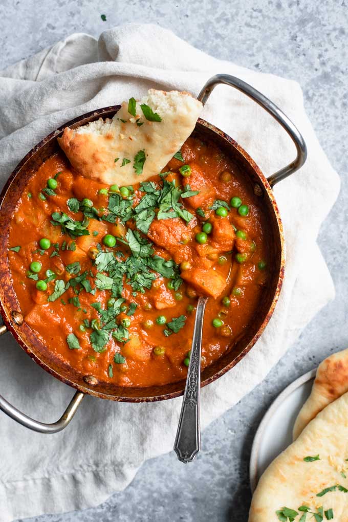 Indian spiced potatoes and peas curry served with garlic naan